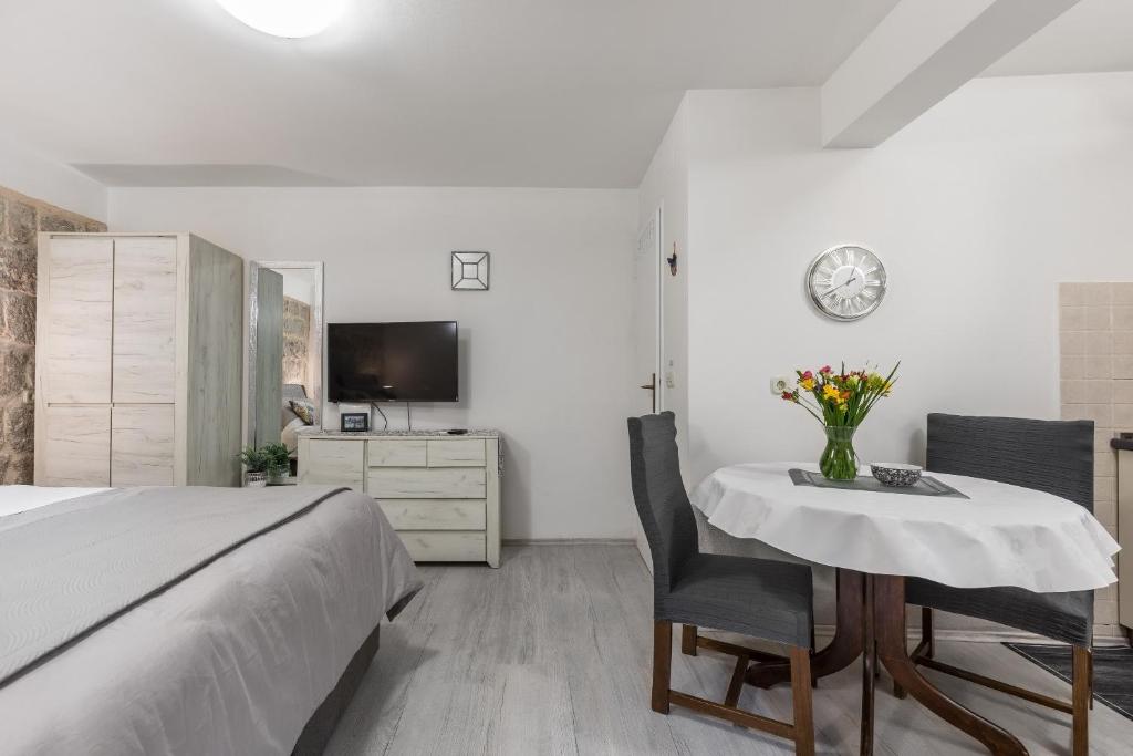 a bedroom with a bed and a table and chairs at Studio Toniko in Split