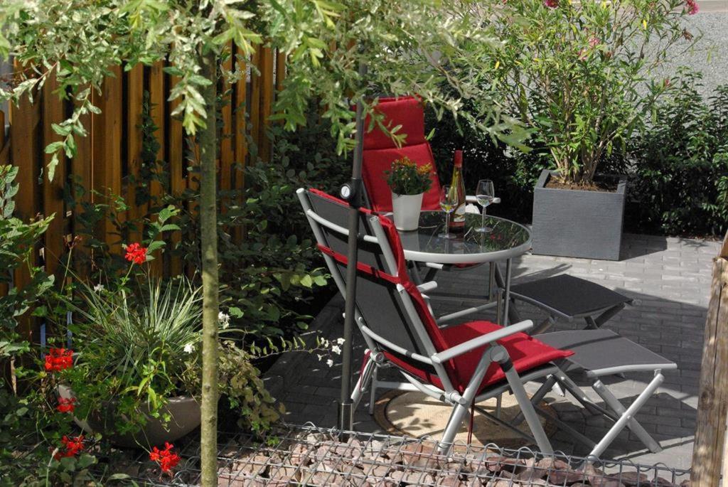 a table and chairs in a garden with plants at Ferienwohnung SaarWeinWald 