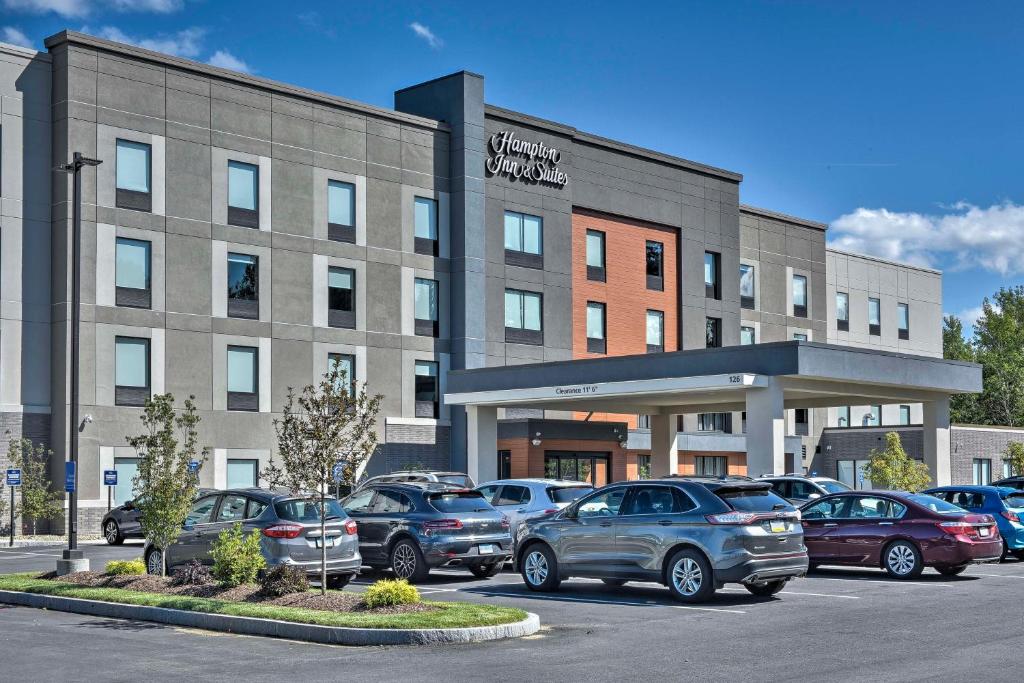 Hampton Inn & Suites Keene في كين: مبنى فيه سيارات متوقفة في موقف للسيارات