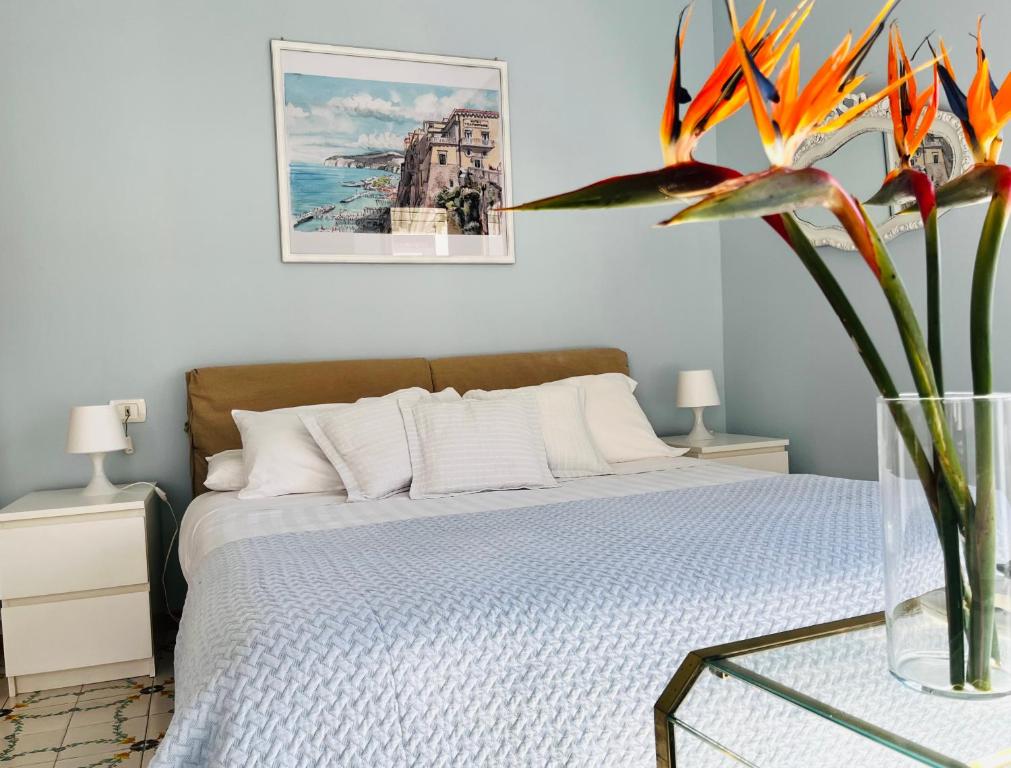 una camera con letto e vaso con fiore di Sorrento Home Pool family BIG appartament in Sorrento center a Sorrento