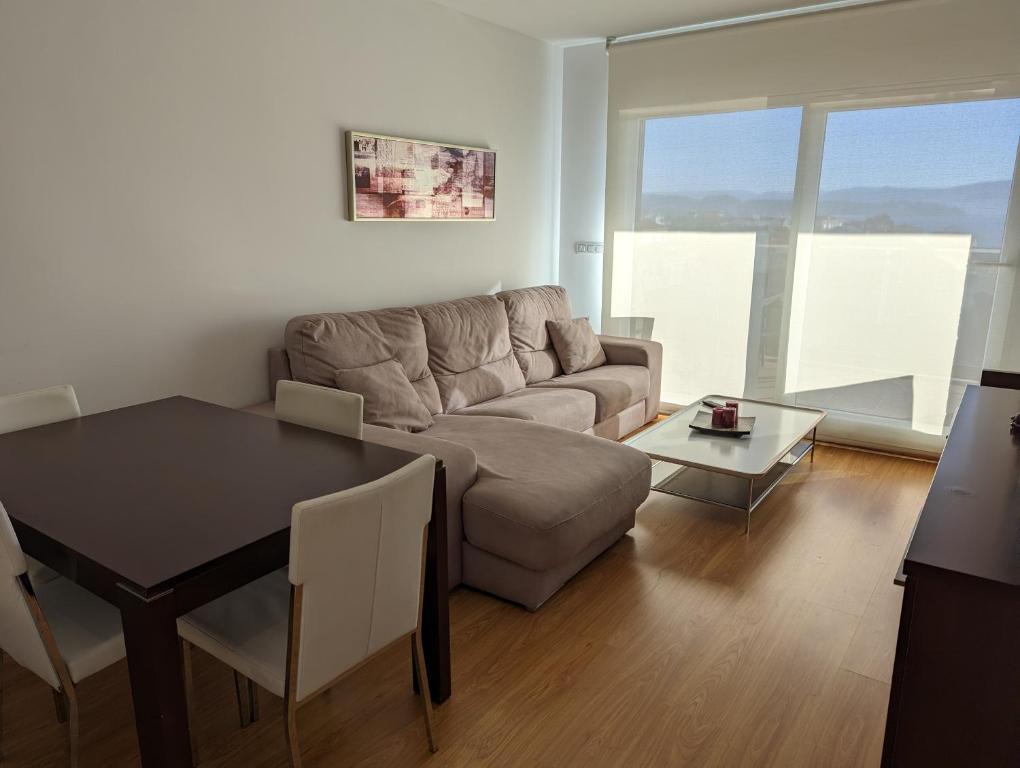 a living room with a couch and a table at Apartamento 2 habitaciones con vistas en la playa in Portonovo