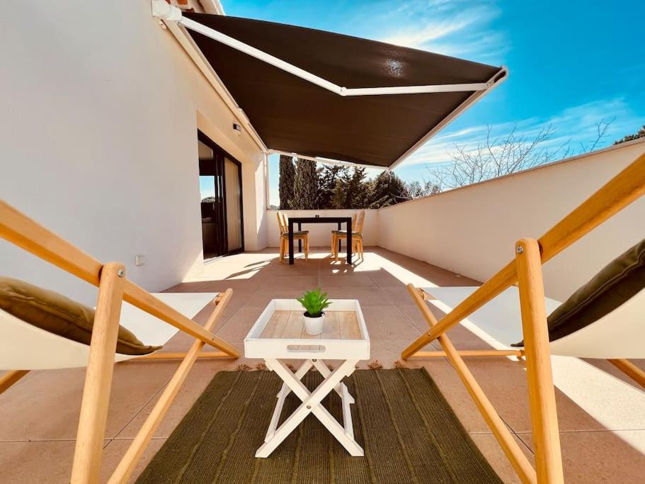 a balcony with a table and chairs on a roof at Romy YourHostHelper in Saint-Cyr-sur-Mer