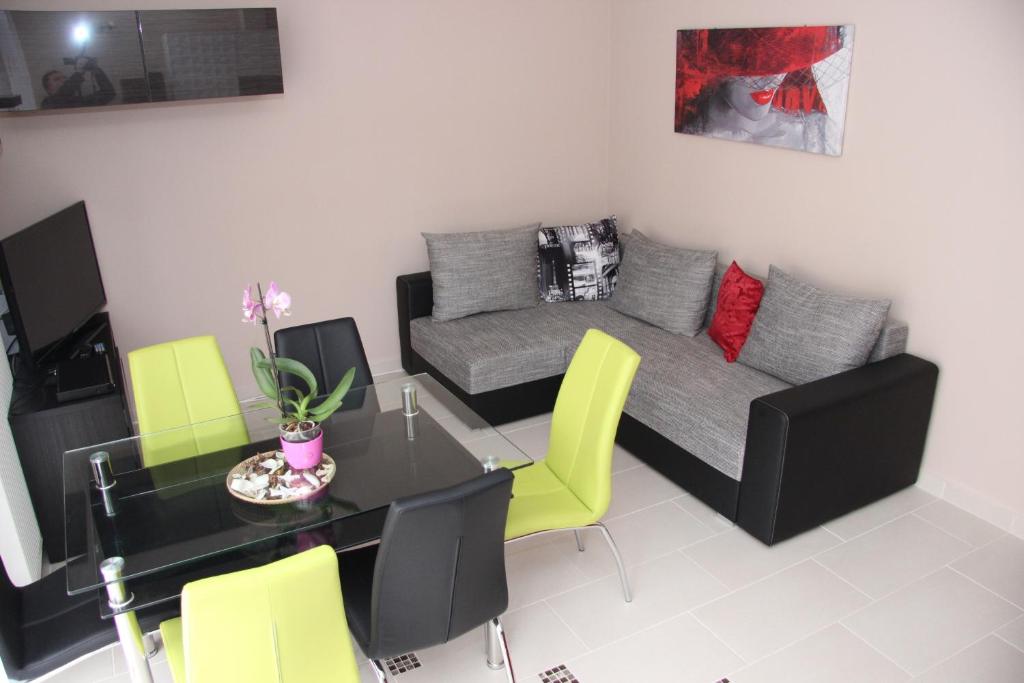 a living room with a table and a couch at Dorina Wellness Apartman in Siófok
