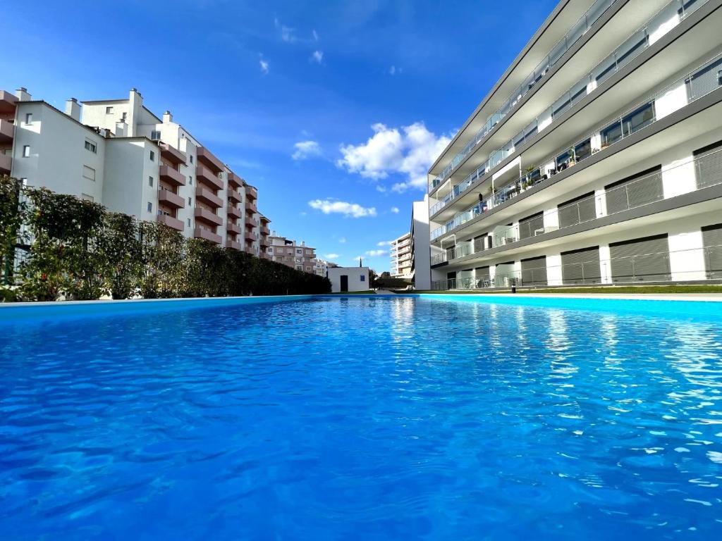een zwembad in het midden van twee gebouwen bij Praia da Rocha Twins 1 With Pool by Homing in Portimão