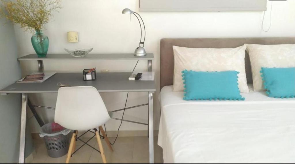a bedroom with a desk and a bed and a chair at Vacations in Patra Studios in Patra