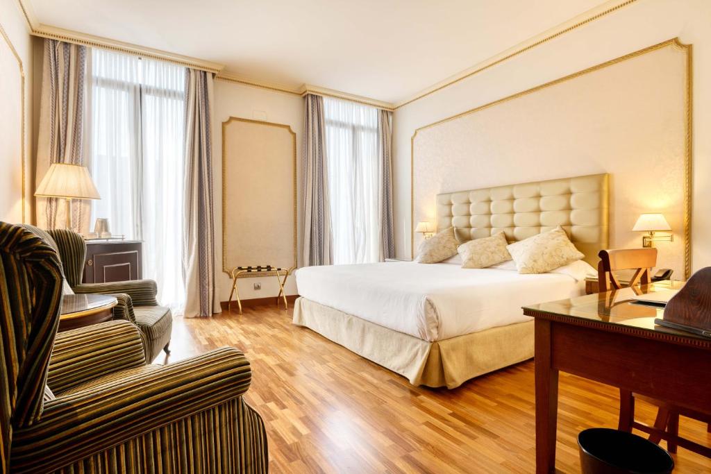 Großes Hotelzimmer mit einem Bett und einem Sofa in der Unterkunft Hotel Roger de Llúria in Barcelona