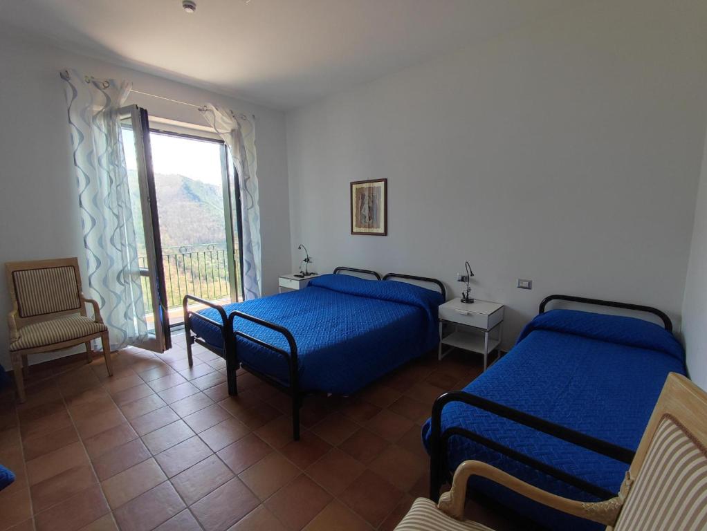 1 Schlafzimmer mit 2 Betten, einem Fenster und einem Stuhl in der Unterkunft Hermitage Ravello in Ravello