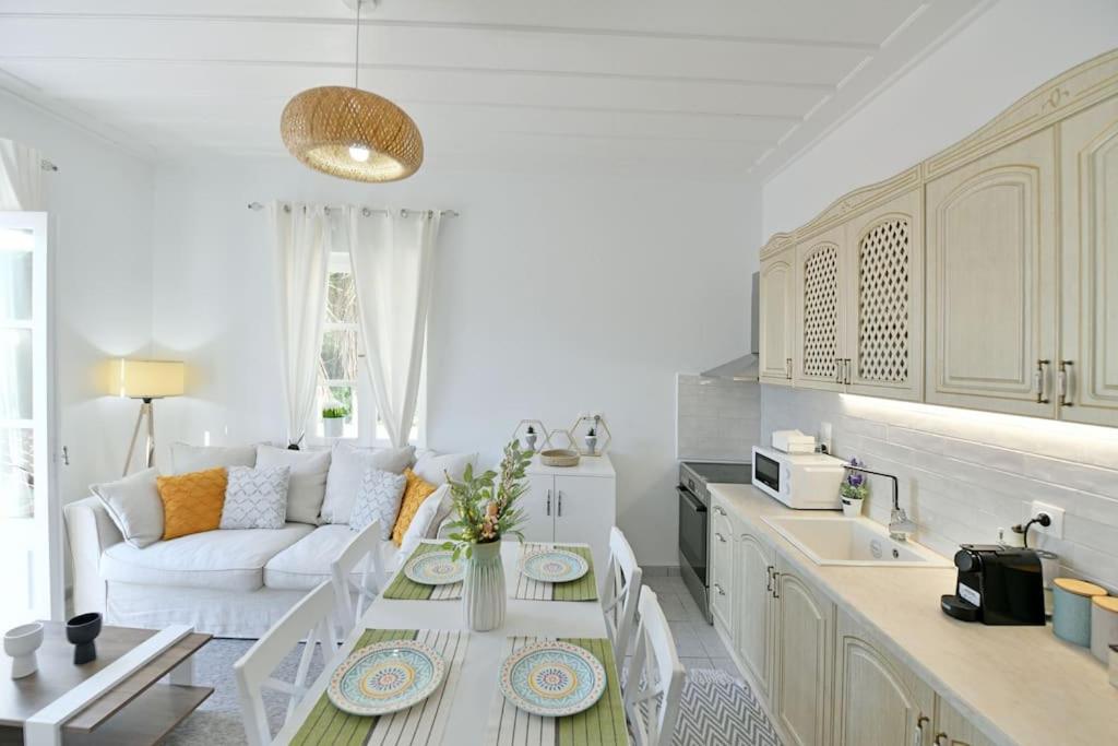 Sala de estar blanca con sofá y mesa en Olivo II Luxury Apartment, en Hydra