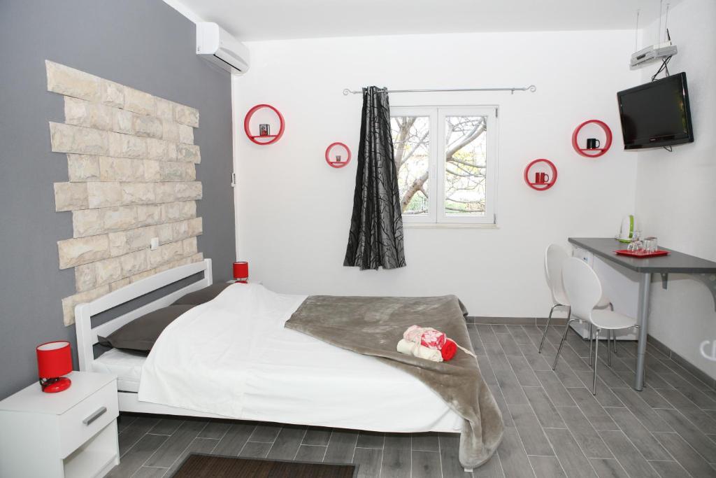 1 dormitorio con cama, escritorio y ventana en Apartments & Room Dijana, en Trogir