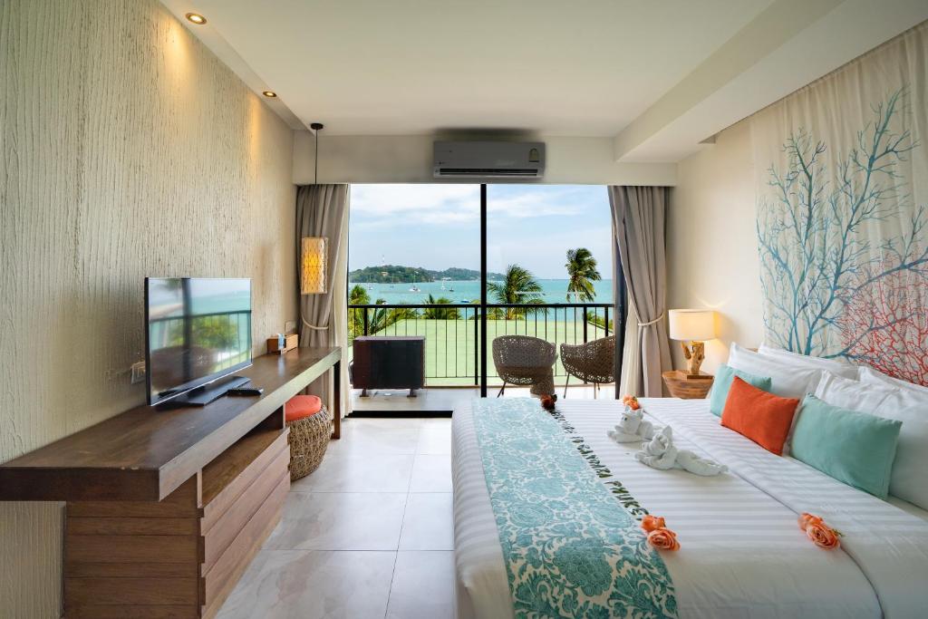 a hotel room with a large bed and a television at Bandara Phuket Beach Resort in Panwa Beach