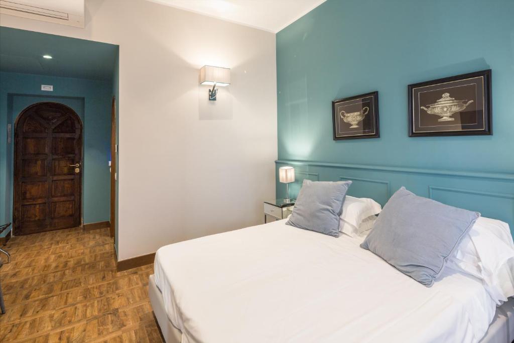 a bedroom with a large white bed with blue walls at Hotel Villa Alberti Portofino Land in Santa Margherita Ligure