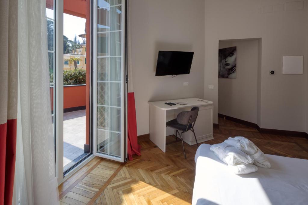 a room with a bed and a desk and a television at Hotel Villa Alberti Portofino Land in Santa Margherita Ligure