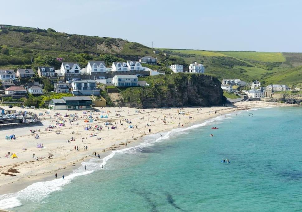 an aerial view of a beach with people in the water at Beach Lovers Paradise in Portreath - With Sea Views & Log Burner just 100m from beach in Portreath