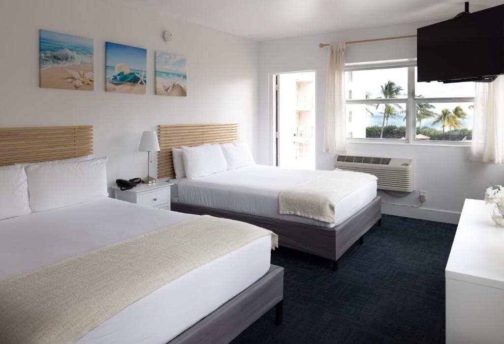 een hotelkamer met 2 bedden en een raam bij Lorraine Hotel in Miami Beach