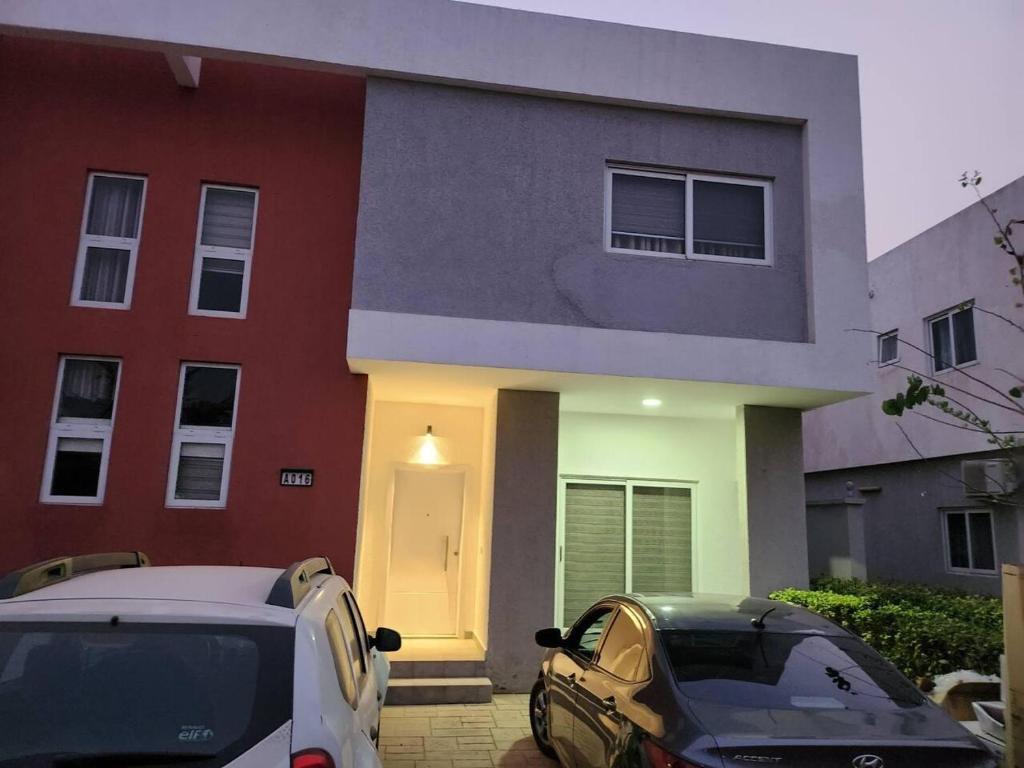 a house with two cars parked in front of it at Spacious Luxury 3Bed Hse in Tema - Netflix Wi-fi in Dawhwenya
