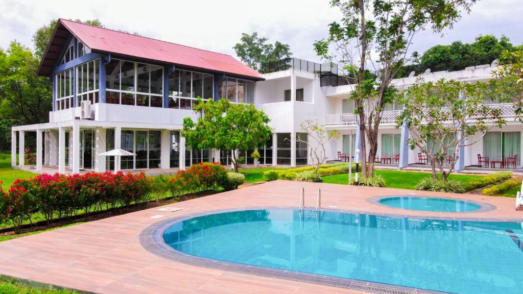 una casa con piscina frente a un edificio en Lavendish Wild Safari en Wasgamuwa