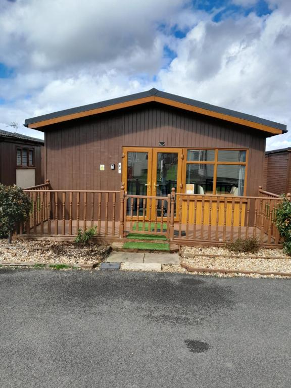 a small house with a porch and a fence at Perfect chalet to relax in k4 in Mablethorpe