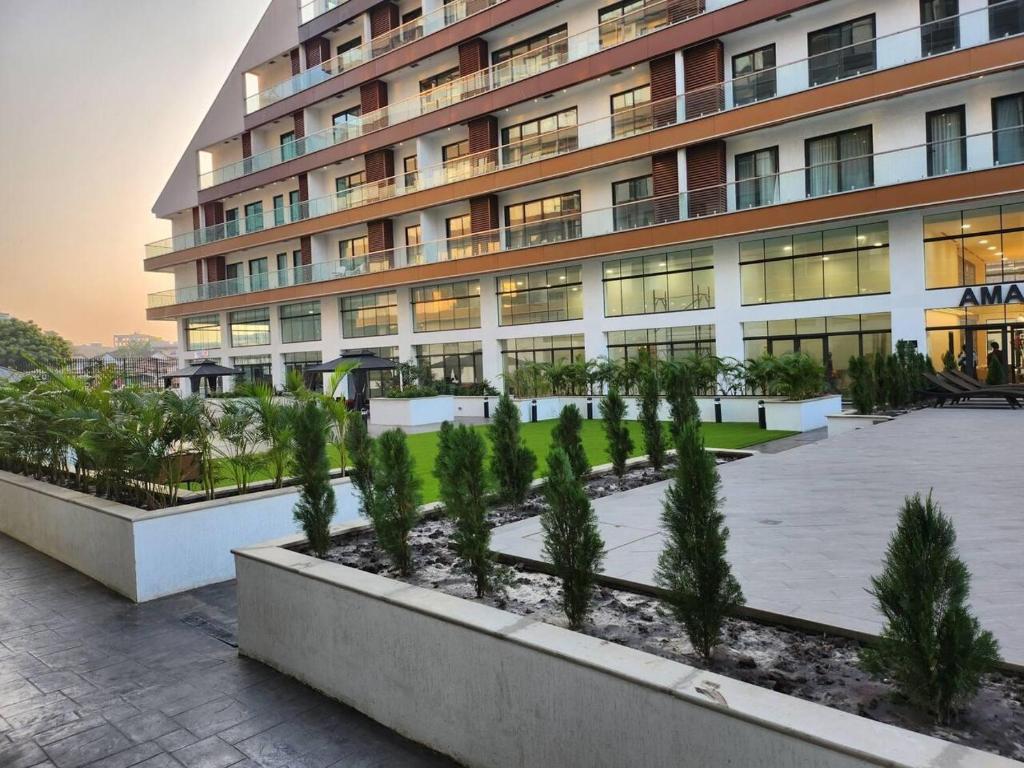 Un gran edificio con árboles delante. en Luxurious & Comfy Gem-5 Star Location-Pools Gym!, en Accra
