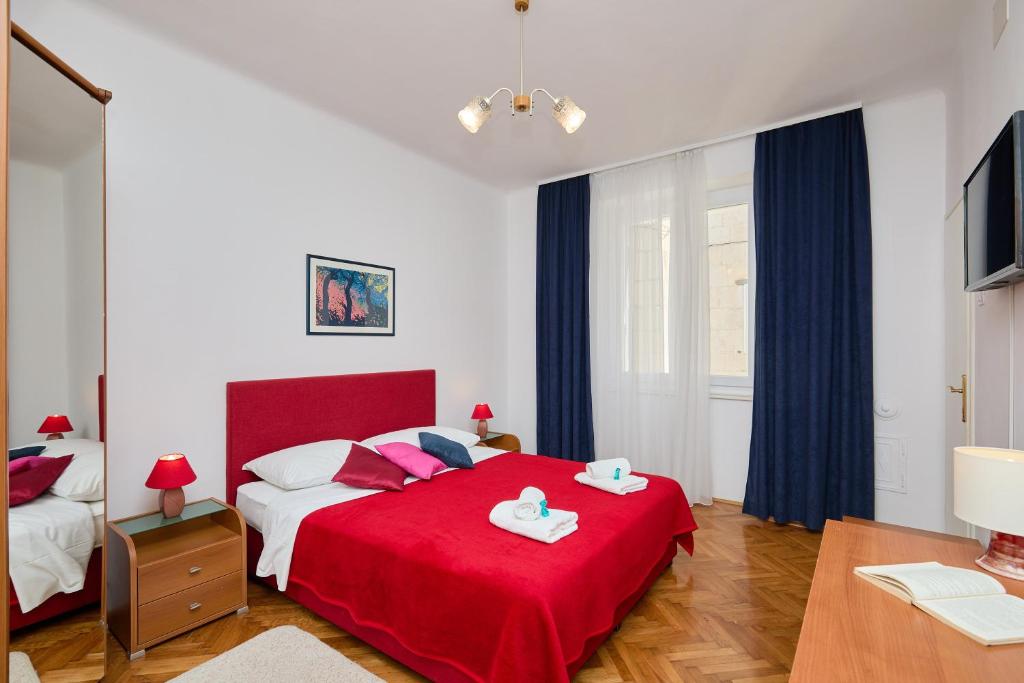 - une chambre avec un lit rouge et une couverture rouge dans l'établissement SeaView Apartment Ploce, à Dubrovnik
