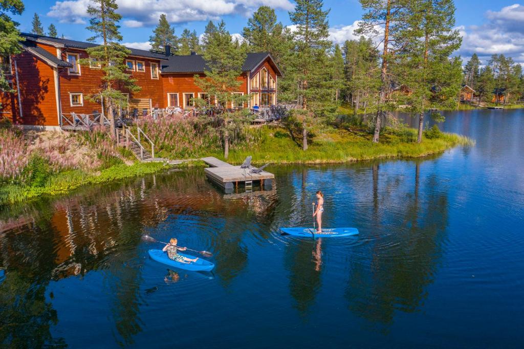 deux personnes sont debout sur des planches de surf dans l'eau dans l'établissement Pinetree Lodge, à Kangos