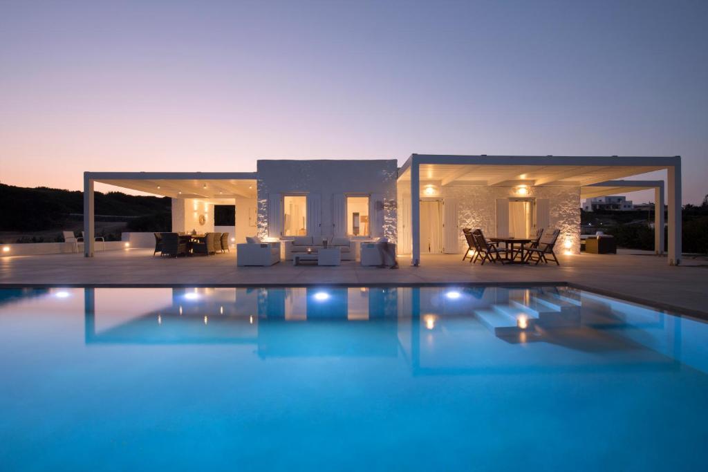 a villa with a swimming pool at night at White Santa Maria Villa in Santa Maria