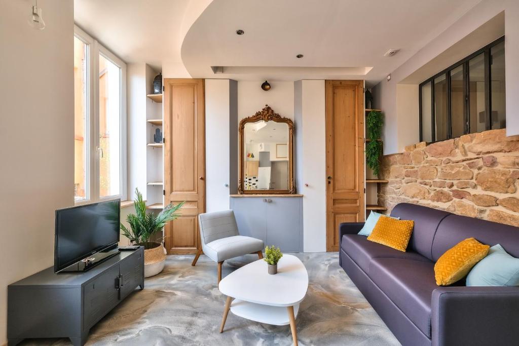 卡魯雷埃奎耶的住宿－Appartement Le Cosy - Calme & Chaleureux - Bien situé，客厅配有紫色沙发和电视
