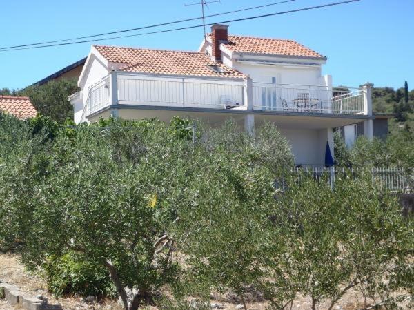 een groot wit huis met een balkon en bomen bij Apartment in Slatine with sea view, terrace, air conditioning, WiFi 5147-1 in Slatine