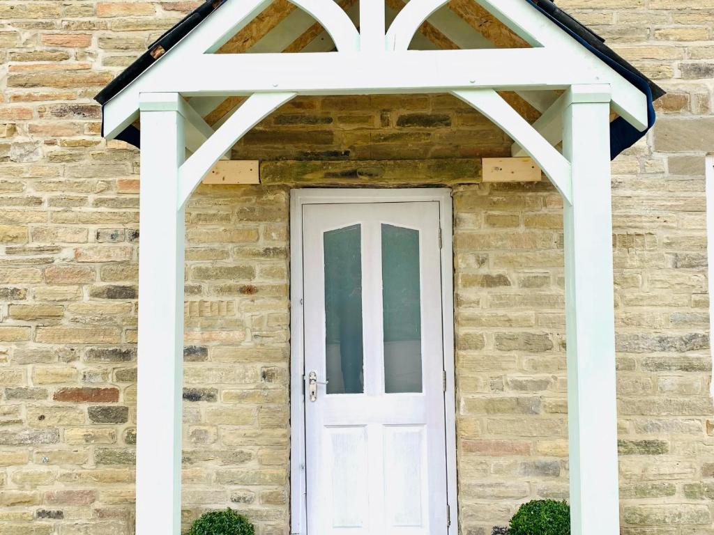 a white door on a brick building with a window at Marina Apartments in Bradford