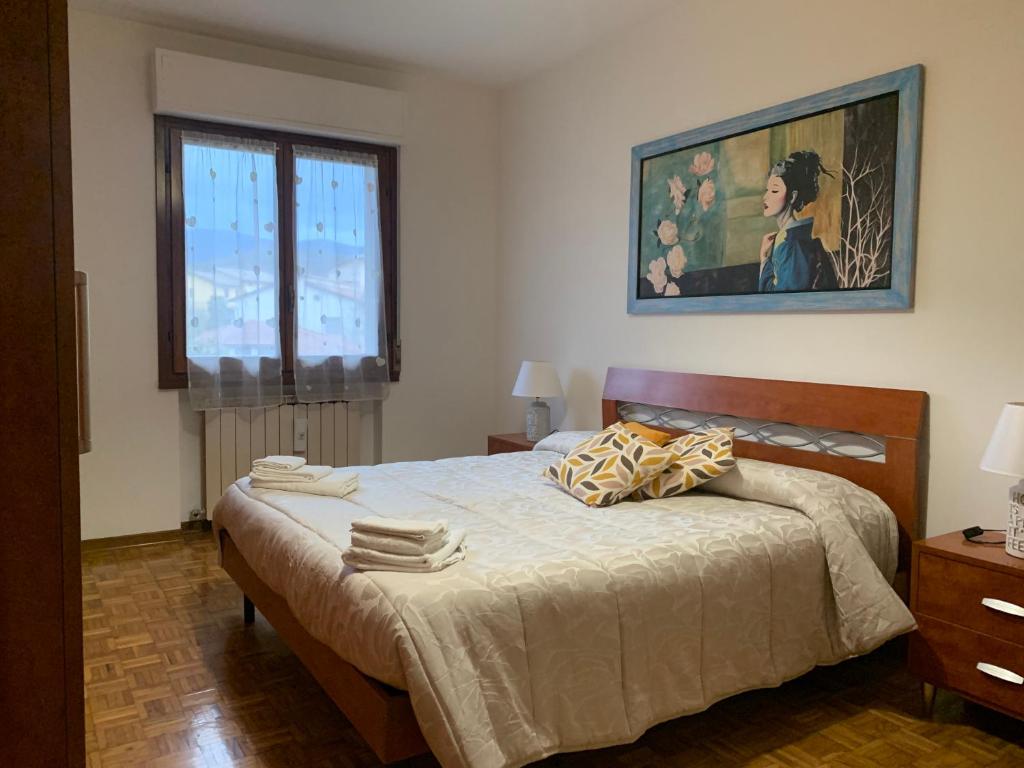 a bedroom with a bed and a painting on the wall at Casa di Lea in Bibbiena