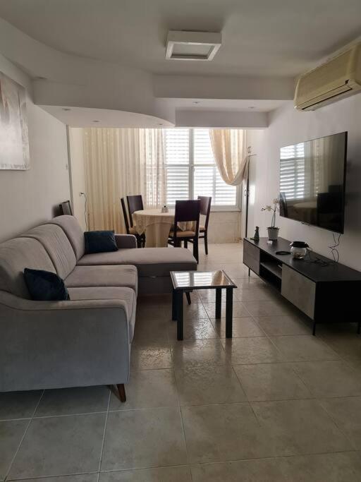 a living room with a couch and a table at Lovely Apt Close to Beach in Nahariyya