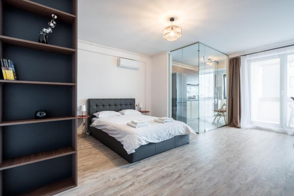 een slaapkamer met een bed en een glazen wand bij Kondo studio I Roka Residence, Timpuri Noi in Boekarest