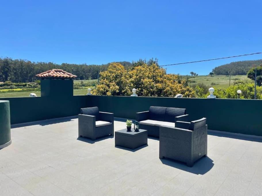 un patio con 2 sofás, una mesa y sillas en La Macadamia en La Laguna