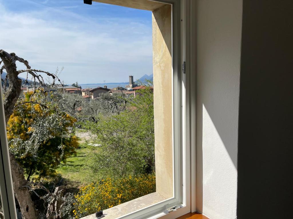 une fenêtre ouverte avec vue sur un champ dans l'établissement Villa Carrera, à Malcesine