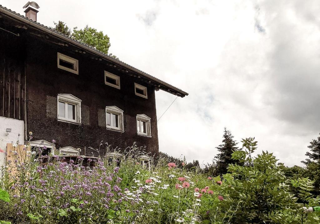 una casa con un campo de flores delante de ella en Villa Roc, en Grünenbach