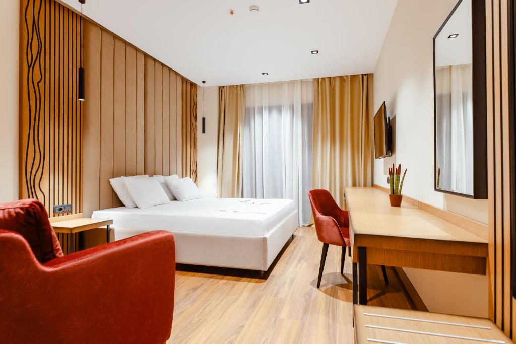 een hotelkamer met een bed en een bureau bij Valza Boutique Hotel in Vlorë