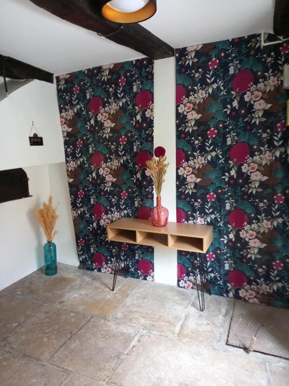 a room with a table with a floral wallpaper at l'univers, vous et nous in Pouilly-sur-Vingeanne