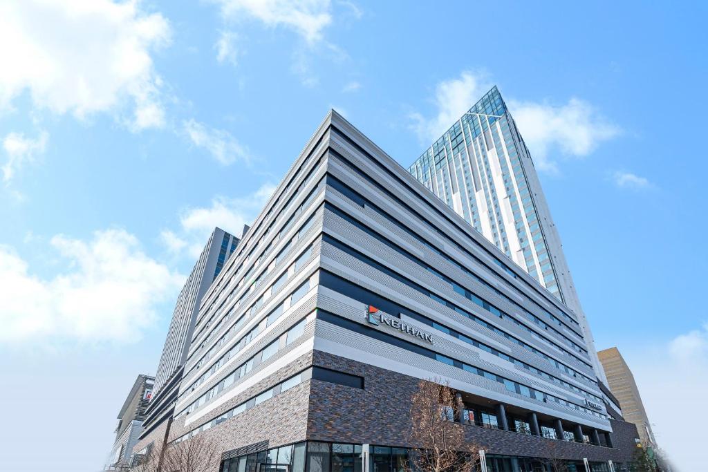 大阪的住宿－Hotel Keihan Namba Grande，一座高大的建筑,旁边有一个标志