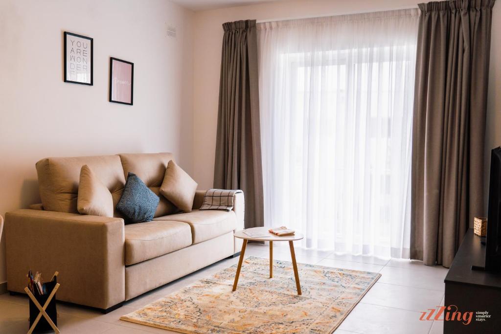 a living room with a couch and a table at Modern Apartments in Malta's charming Mosta in Mosta