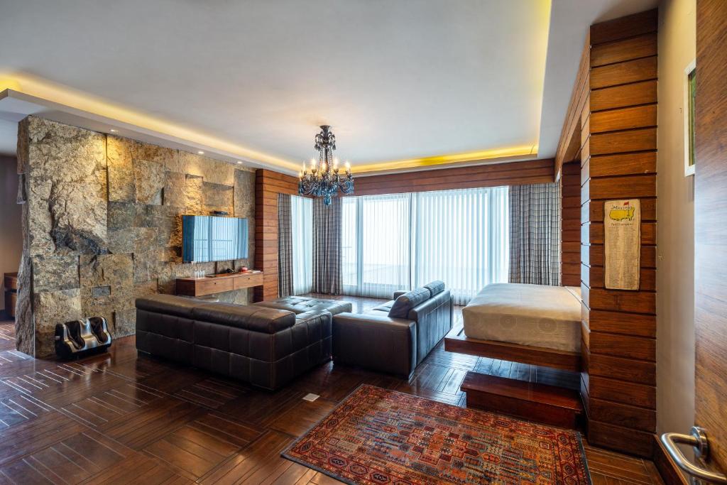 a living room with a couch and a bed at amã Stays & Trails Kailash House in Kodaikānāl