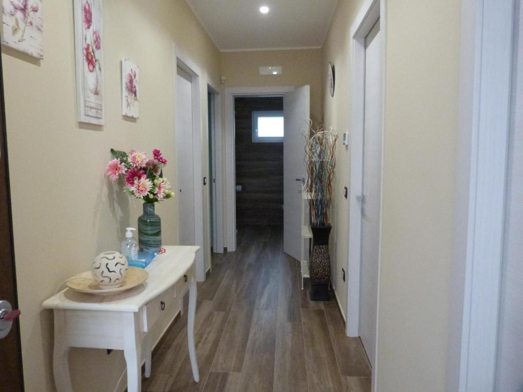 a hallway with a table with flowers in a vase at HOME SWEET HOME in Sammichele di Bari