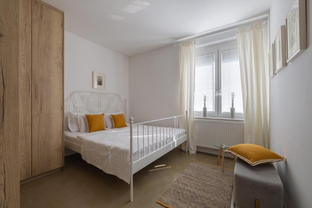 a bedroom with a white bed with yellow pillows at City Central in Ljubljana