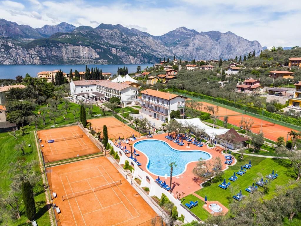 Club Hotel Olivi - Tennis Center في مالسيسيني: اطلالة جوية على منتجع مع ملعب تنس