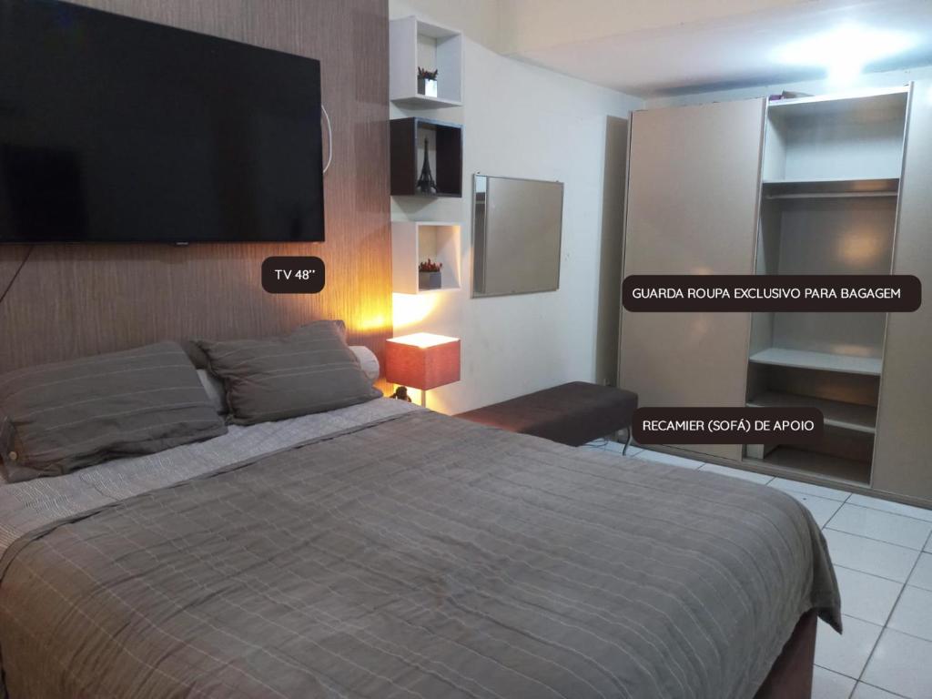 a bedroom with a bed and a flat screen tv at ED House in Fortaleza