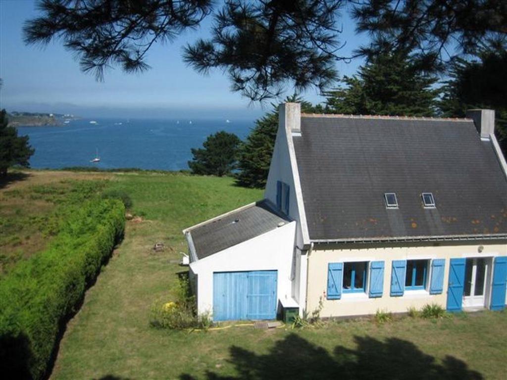a house on a hill with the ocean in the background at Maison Le Palais, 5 pièces, 8 personnes - FR-1-418-159 in Le Palais