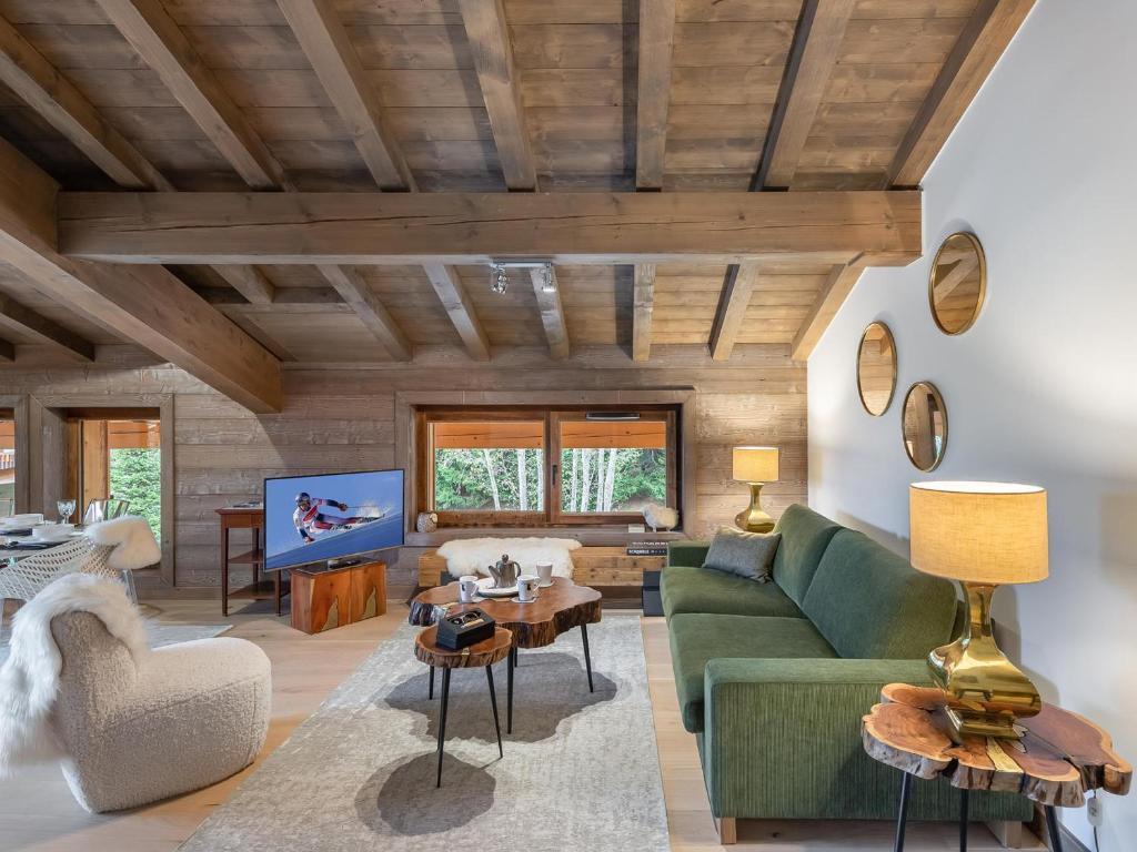 - un salon avec un canapé vert et une télévision dans l'établissement Appartement chaleureux à Megève avec sauna et parking - FR-1-569-55, à Megève