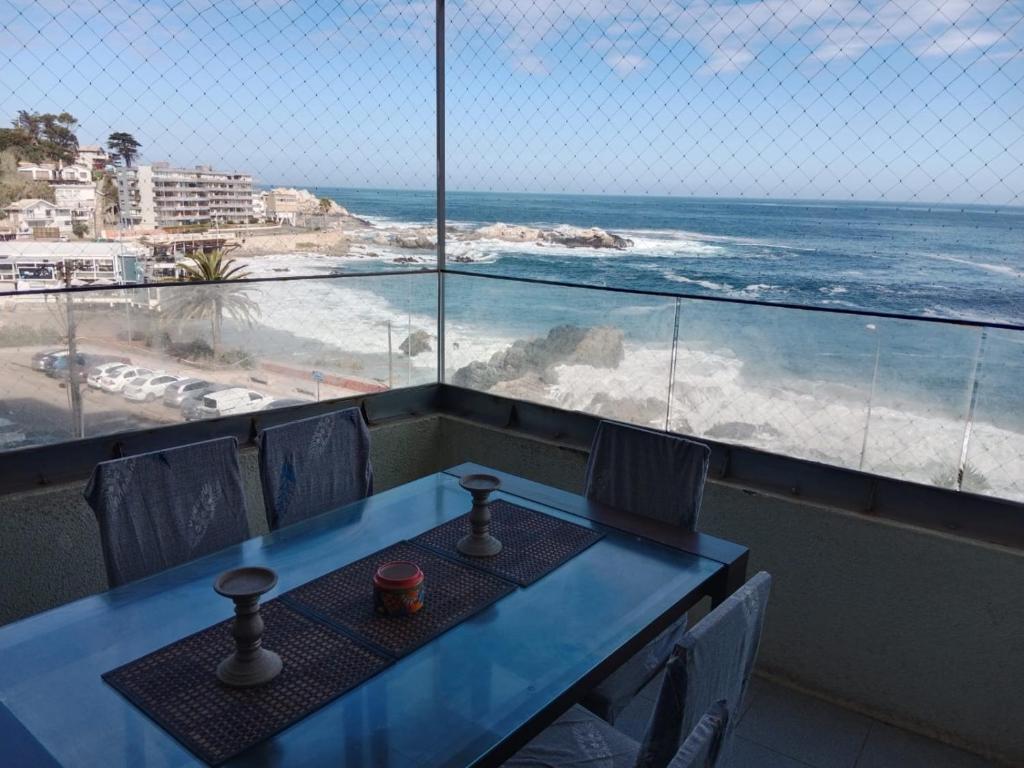 比尼亞德爾馬的住宿－FRENTE AL MAR，一张桌子和椅子,享有海滩美景