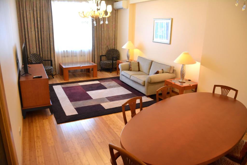 Premium Apartments Baku في باكو: غرفة معيشة مع طاولة وأريكة