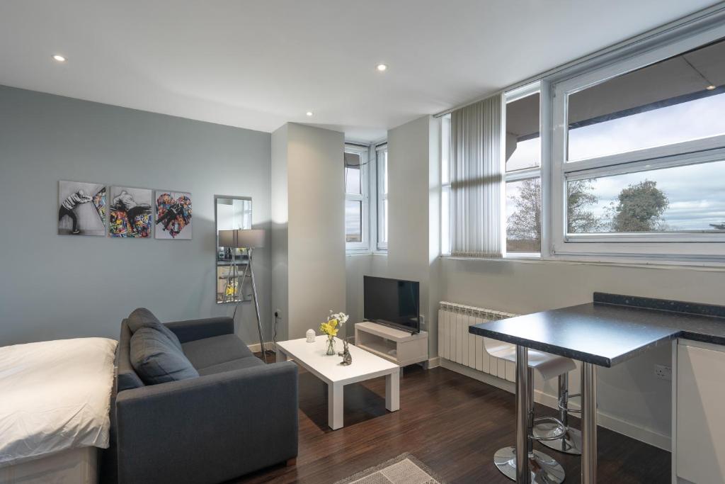 a living room with a bed and a desk and a couch at Superb Studio in London