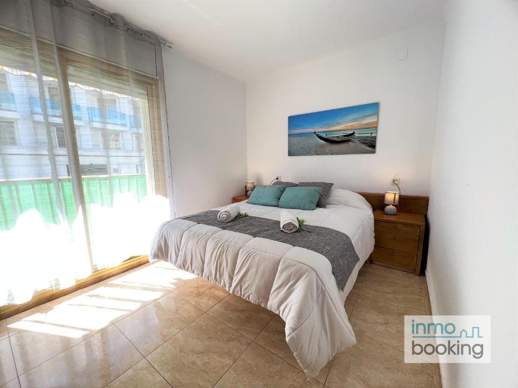 - une chambre avec un lit et une grande fenêtre dans l'établissement New Pins II, climatizado y a 120m de la playa, à Cambrils