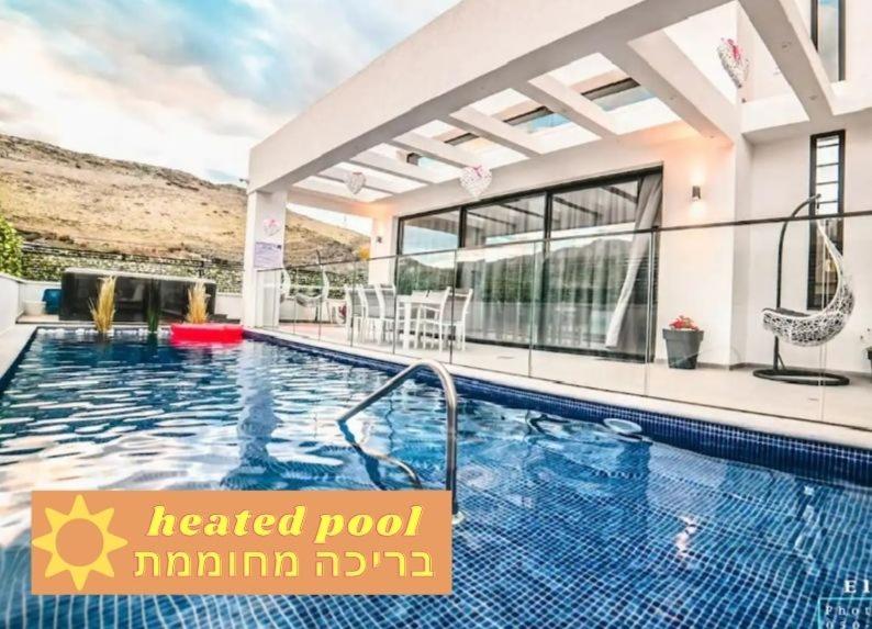 ein Pool in einem Haus mit einem Haus in der Unterkunft וילה לה וידה in Migdal